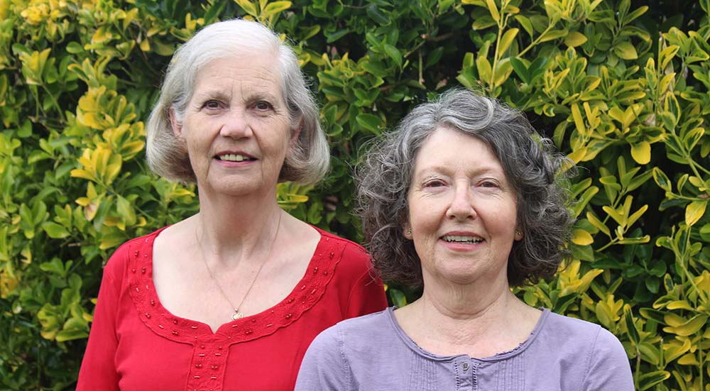 A photo of Jacqui and Jan against a leafy background